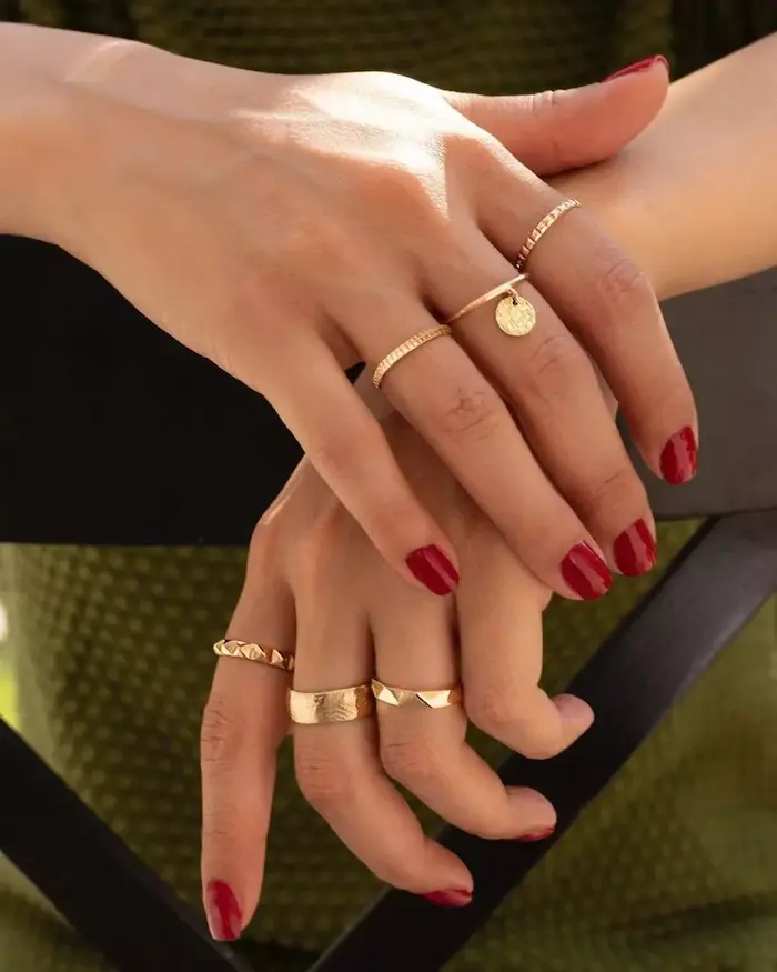 ست کردن چند انگشتر طلا در دستان یک خانم با لاک های قرمز 151456